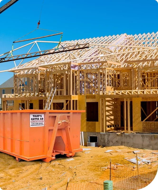 an orange roll off container at a construction site
