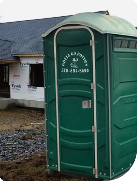 a green portable toilet unit from Gotta Go Potties at a construction site